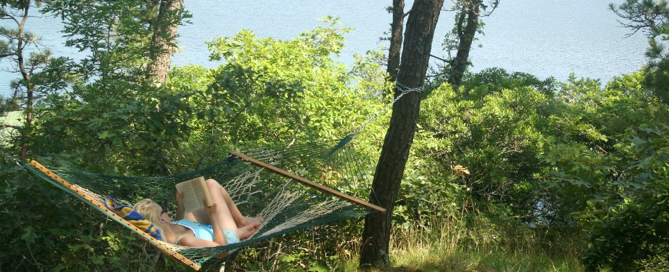 girl reading book on hammock